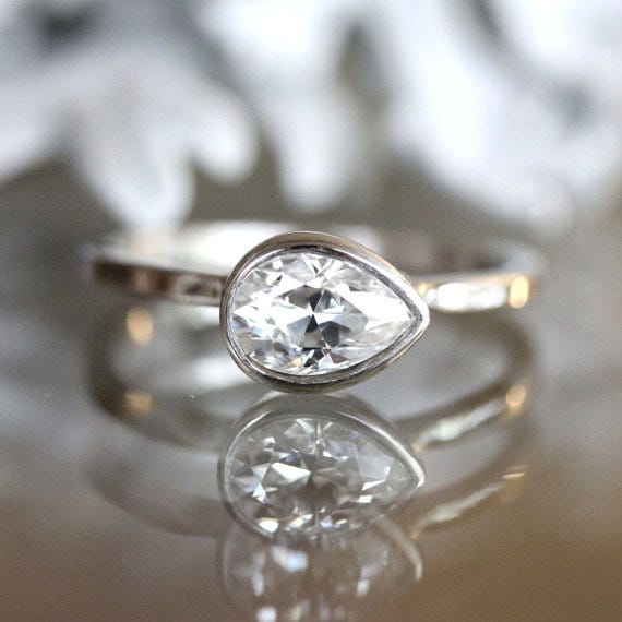 We love this east-west pear cut moissanite ring from louisagallery on Etsy!