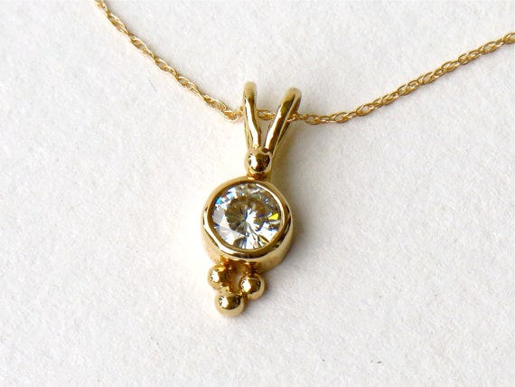This moissanite and recycled gold pendant necklace would make a great gift for someone in your bridal party! VakaStudio on Etsy, from $350